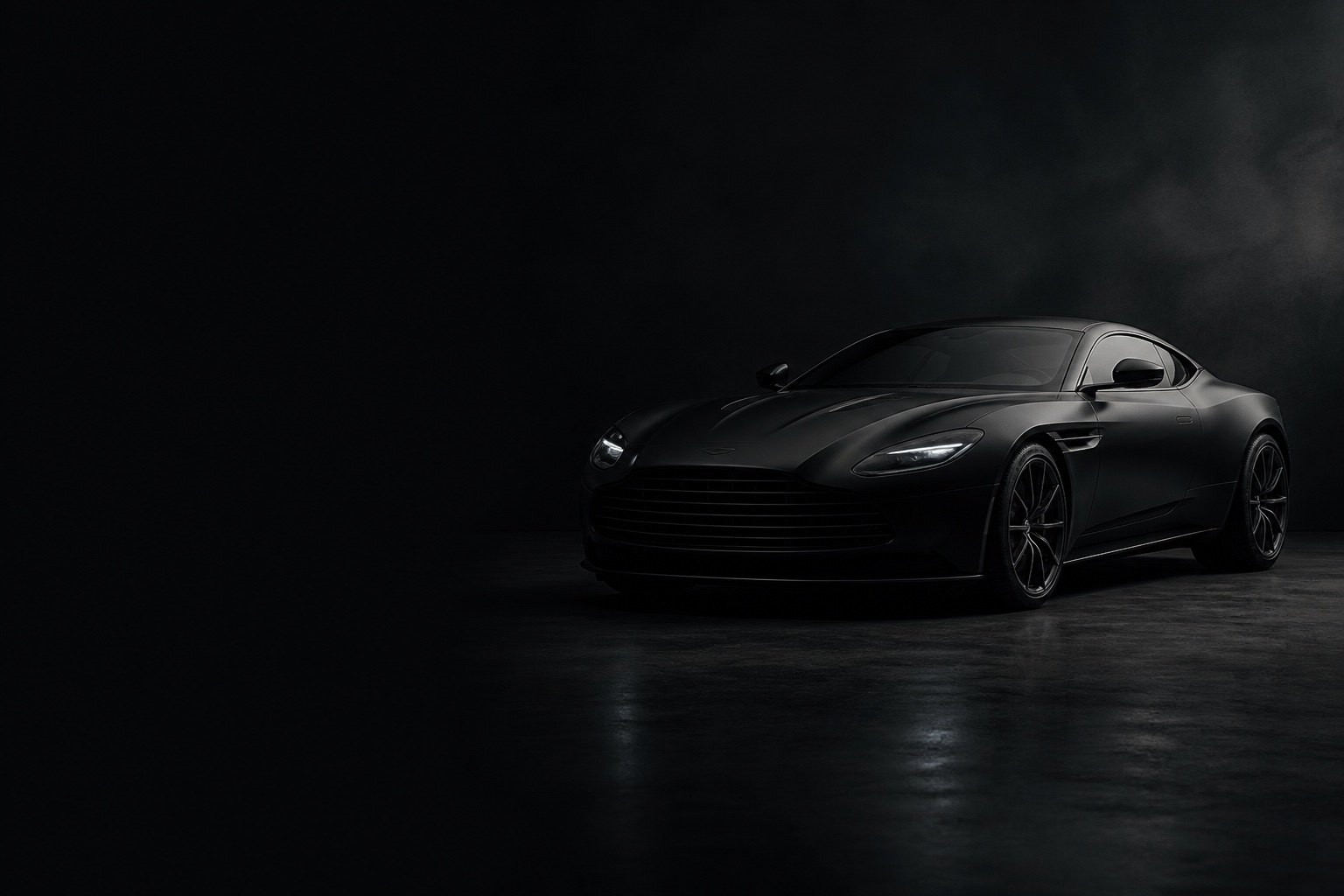 Still from an automotive film: a dark sports car in a low-key studio